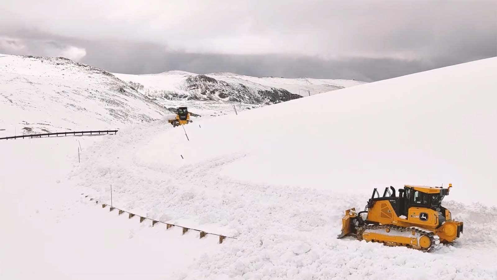 A pair of snowplows work to clear the Beartooth Highway.